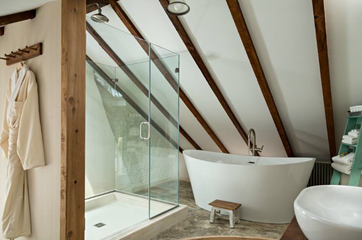 Rustic vaulted bathroom with walk-in shower with glass doors, modern freestanding tub and exposed beams